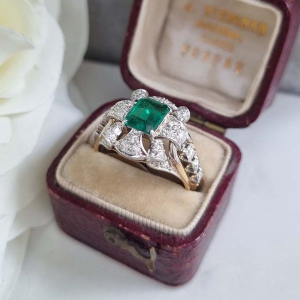 Vintage Colombian Emerald and Diamond Cluster Dress Ring, 0.81ct emerald-cut Colombian emerald within decorative fan design diamond surround to arched shoulders with central diamonds in 18ct yellow gold. Circa 1950s