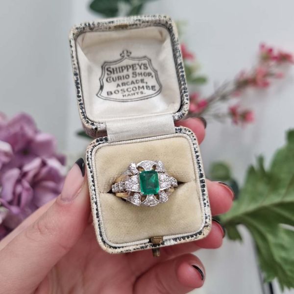 Vintage Colombian Emerald and Diamond Cluster Dress Ring, 0.81ct emerald-cut Colombian emerald within decorative fan design diamond surround to arched shoulders with central diamonds in 18ct yellow gold. Circa 1950s