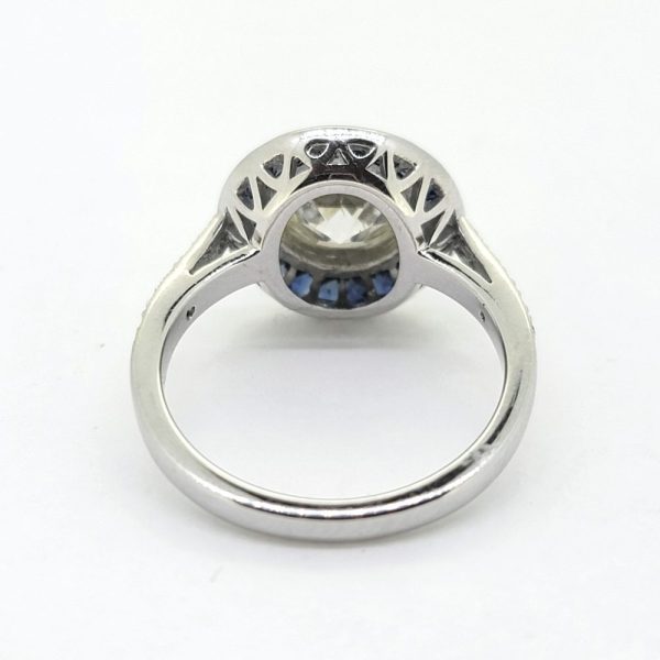 2.22ct Old Cut Diamond and Calibre Sapphire Target Cluster Engagement Ring, 2.22ct old-cut diamond surrounded by a halo of blue sapphires