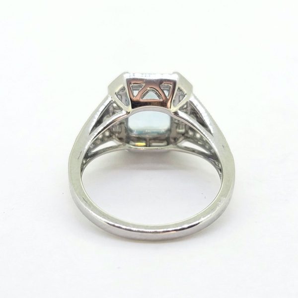 Contemporary Aquamarine and Diamond Cluster Dress Engagement Ring in 18ct White Gold, 1.85ct emerald-cut aquamarine surrounded by baguette-cut diamond halo with brilliant diamond accents to each corner with tapered diamond-set shoulders
