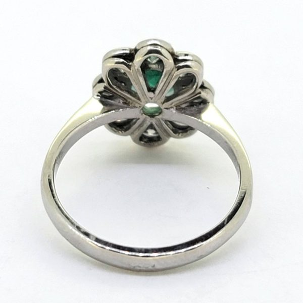 1.10ct Emerald and Diamond Floral Cluster Engagement Ring, 1.10ct oval emerald surrounded by 0.96cts round brilliant-cut diamonds in classic flower design in 18ct white gold