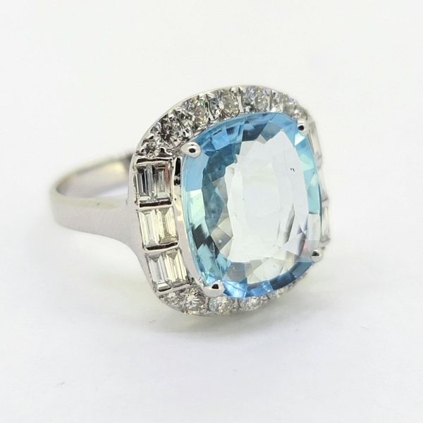 Contemporary 4.64ct Cushion Cut Aquamarine and Diamond Cluster Ring, 4.64ct cushion-shaped aquamarine surrounded by diamonds, with brilliant-cut diamonds to the top and bottom accented with baguette-cut diamonds to the sides in 18ct white gold