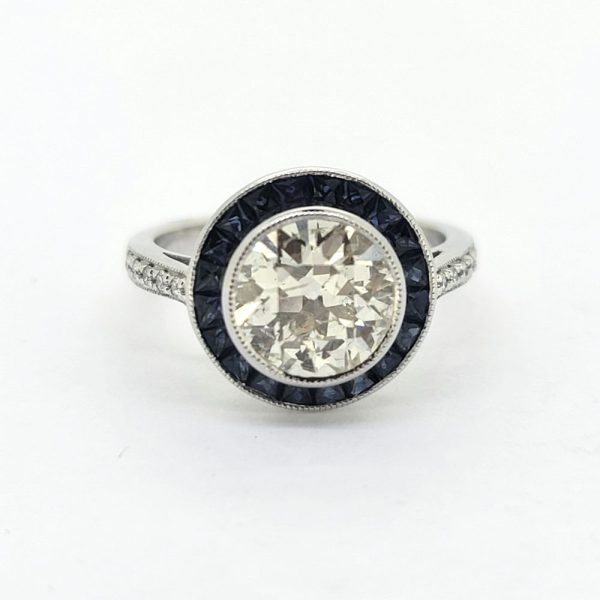 2.22ct Old Cut Diamond and Calibre Sapphire Target Cluster Engagement Ring, 2.22ct old-cut diamond surrounded by a halo of blue sapphires