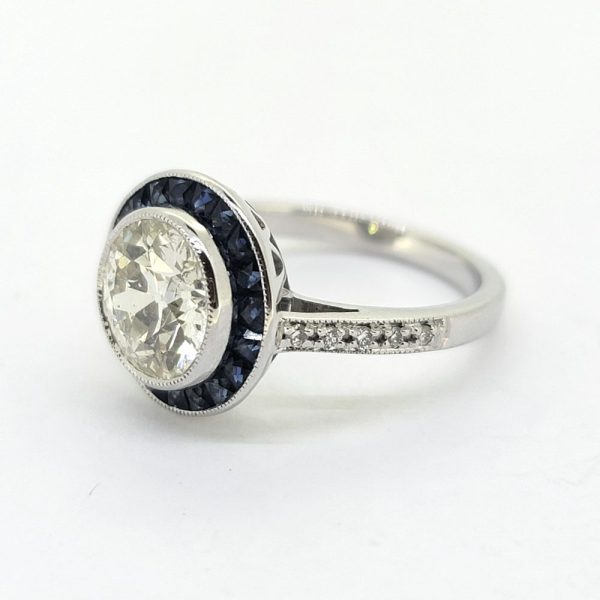 2.22ct Old Cut Diamond and Calibre Sapphire Target Cluster Engagement Ring, 2.22ct old-cut diamond surrounded by a halo of blue sapphires