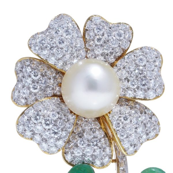 Floral brooch with pearl, diamonds and emeralds in gold.