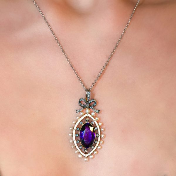 Edwardian Antique Marquise Amethyst Pearl and Diamond Pendant, marquise-cut amethyst surrounded by rose-cut diamonds within white enamel border with gold detailing and natural pearls to outer edge with diamond-set bow bail