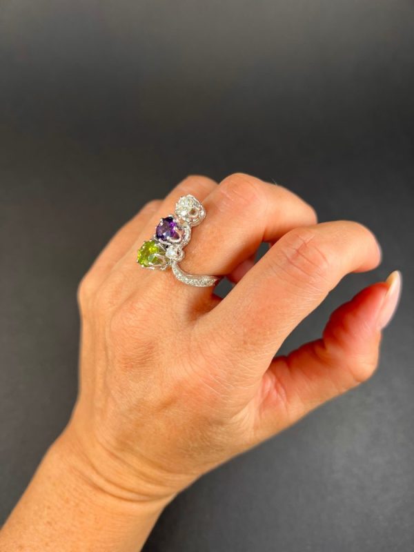 Edwardian Antique French Suffragette Amethyst Peridot Diamond Three Stone Ring, graduating trilogy of peridot amethyst and diamond arranged vertically up the finger when worn in 18ct white gold on diamond-set band with French eagles head stamp