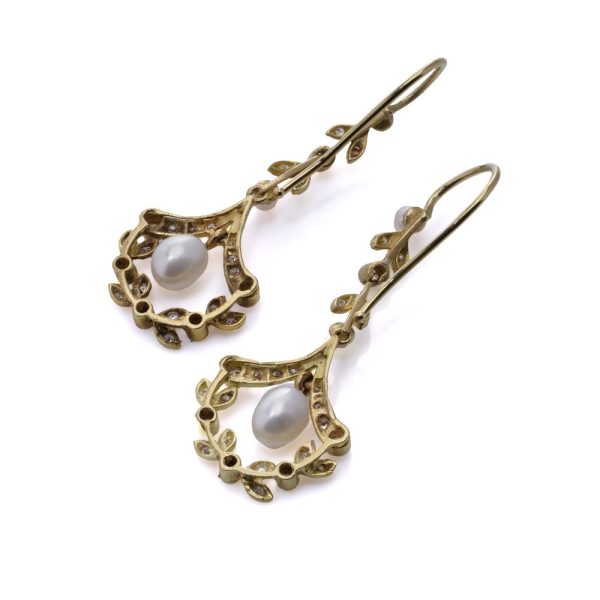 Diamond and pearl drop earrings in gold.