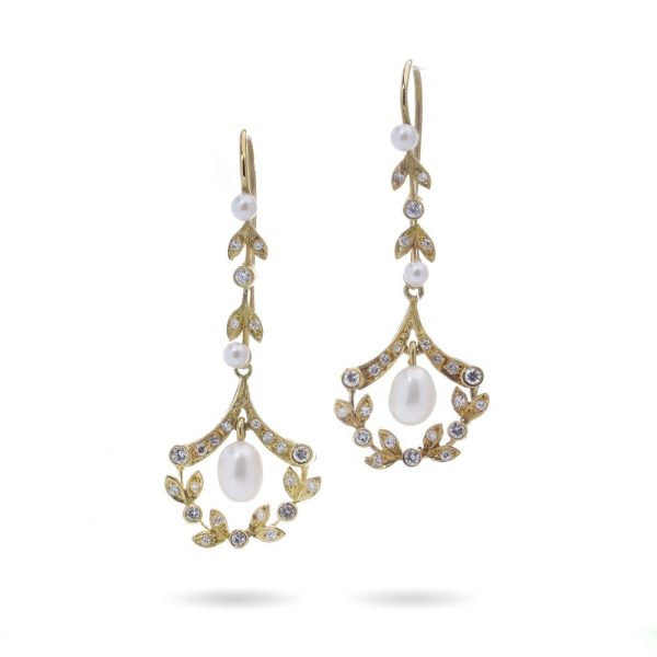 Diamond and pearl drop earrings in gold.