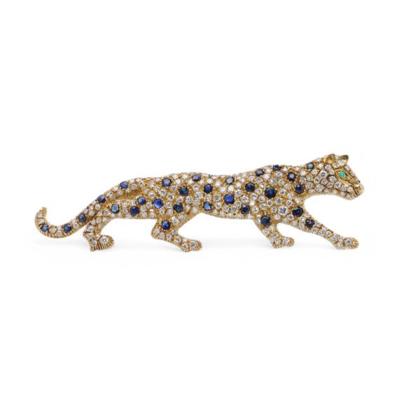 Gold panther brooch with diamonds, sapphires and an emerald.