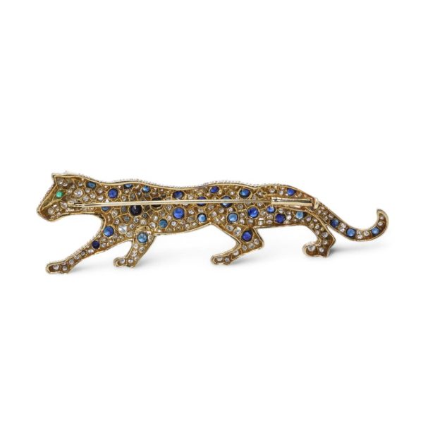 Gold panther brooch with diamonds, sapphires and an emerald.