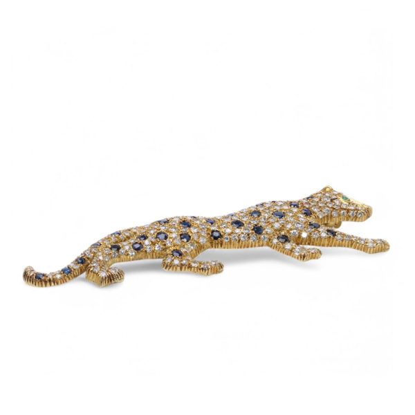 Gold panther brooch with diamonds, sapphires and an emerald.