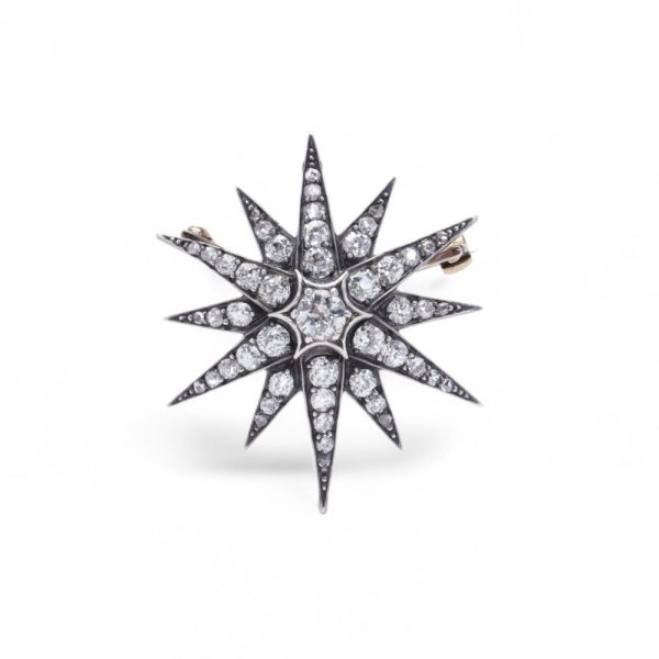 Victorian diamond sunburst star brooch in gold and silver.