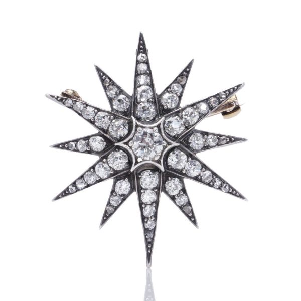 Victorian diamond sunburst star brooch in gold and silver.