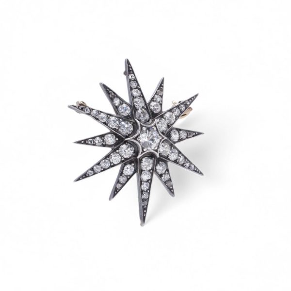 Victorian diamond sunburst star brooch in gold and silver.