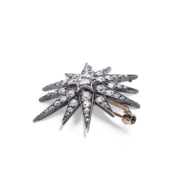 Victorian diamond sunburst star brooch in gold and silver.