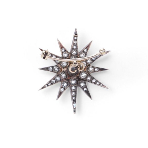 Victorian diamond sunburst star brooch in gold and silver.