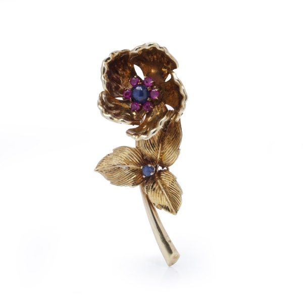 Gold flower brooch with sapphires and rubies.
