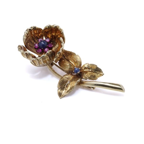 Gold flower brooch with sapphires and rubies.