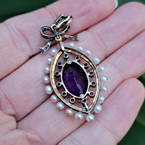 Edwardian Antique Marquise Amethyst Pearl and Diamond Pendant, marquise-cut amethyst surrounded by rose-cut diamonds within white enamel border with gold detailing and natural pearls to outer edge with diamond-set bow bail