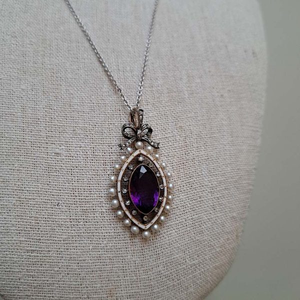 Edwardian Antique Marquise Amethyst Pearl and Diamond Pendant, marquise-cut amethyst surrounded by rose-cut diamonds within white enamel border with gold detailing and natural pearls to outer edge with diamond-set bow bail