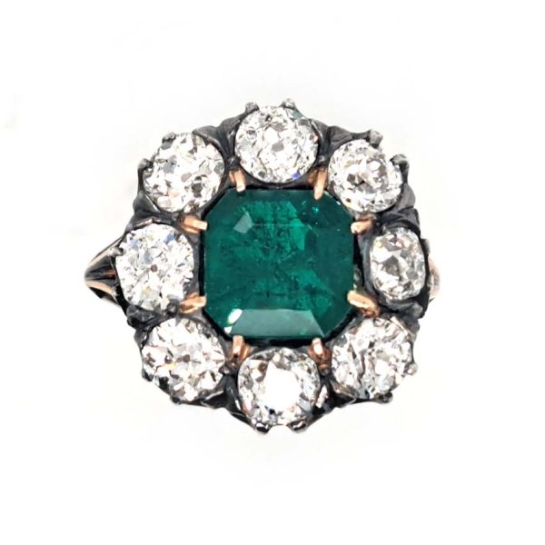 Georgian Regency Antique 2.85ct Colombian Emerald and 4.80ct Old Mine Cut Diamond Cluster Ring in silver upon gold with decorative carved split shank. Circa 1830