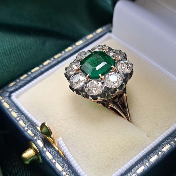Georgian Regency Antique 2.85ct Colombian Emerald and 4.80ct Old Mine Cut Diamond Cluster Ring in silver upon gold with decorative carved split shank. Circa 1830