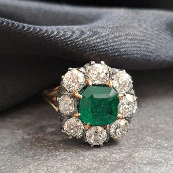 Georgian Regency Antique 2.85ct Colombian Emerald and 4.80ct Old Mine Cut Diamond Cluster Ring in silver upon gold with decorative carved split shank. Circa 1830