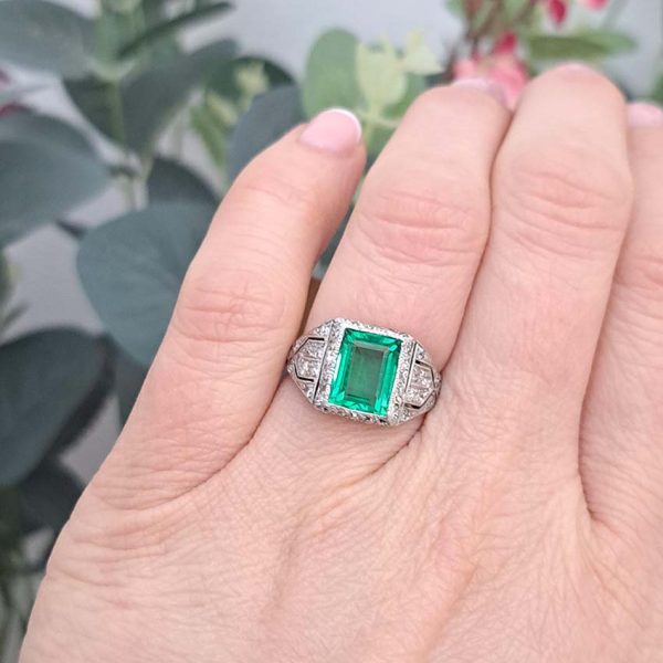Belle Epoque Edwardian Antique 2.10ct Emerald and Diamond Cluster Ring in Platinum, 2.10ct rectangular step-cut vivid green emerald in diamond mount with openwork design to shoulders and scrolling gallery with engraved shank. Circa 1900
