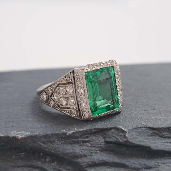 Belle Epoque Edwardian Antique 2.10ct Emerald and Diamond Cluster Ring in Platinum, 2.10ct rectangular step-cut vivid green emerald in diamond mount with openwork design to shoulders and scrolling gallery with engraved shank. Circa 1900
