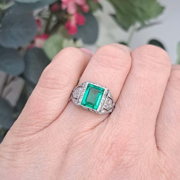 Belle Epoque Edwardian Antique 2.10ct Emerald and Diamond Cluster Ring in Platinum, 2.10ct rectangular step-cut vivid green emerald in diamond mount with openwork design to shoulders and scrolling gallery with engraved shank. Circa 1900