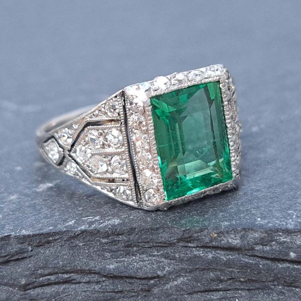 Belle Epoque Edwardian Antique 2.10ct Emerald and Diamond Cluster Ring in Platinum, 2.10ct rectangular step-cut vivid green emerald in diamond mount with openwork design to shoulders and scrolling gallery with engraved shank. Circa 1900