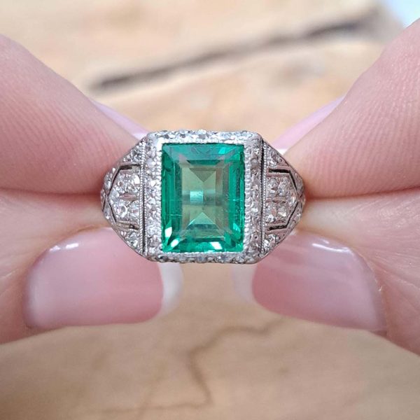 Belle Epoque Edwardian Antique 2.10ct Emerald and Diamond Cluster Ring in Platinum, 2.10ct rectangular step-cut vivid green emerald in diamond mount with openwork design to shoulders and scrolling gallery with engraved shank. Circa 1900