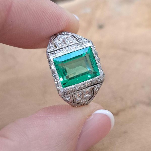 Belle Epoque Edwardian Antique 2.10ct Emerald and Diamond Cluster Ring in Platinum, 2.10ct rectangular step-cut vivid green emerald in diamond mount with openwork design to shoulders and scrolling gallery with engraved shank. Circa 1900