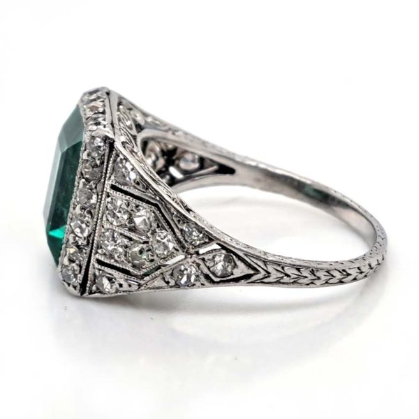 Belle Epoque Edwardian Antique 2.10ct Emerald and Diamond Cluster Ring in Platinum, 2.10ct rectangular step-cut vivid green emerald in diamond mount with openwork design to shoulders and scrolling gallery with engraved shank. Circa 1900