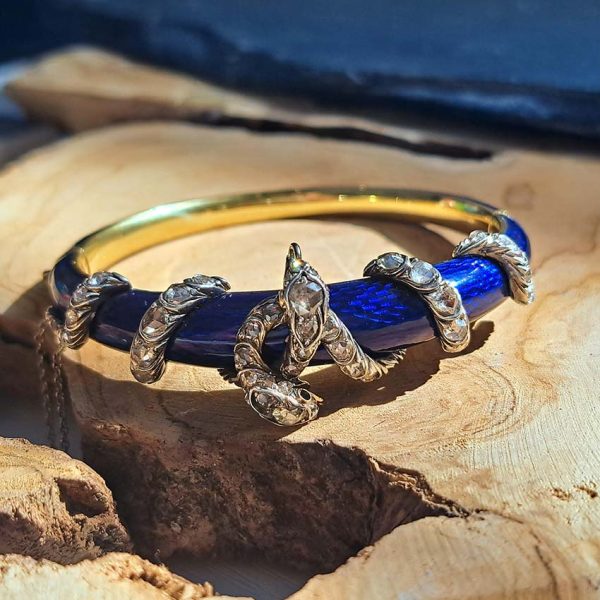 Victorian Antique Blue Enamel and Diamond Set Gold Snake Bangle Bracelet, two entwined diamond set silver snakes on dark blue guilloché enamel tapering hinged gold bangle. Mid 19th century Circa 1850. Presented in antique double door case