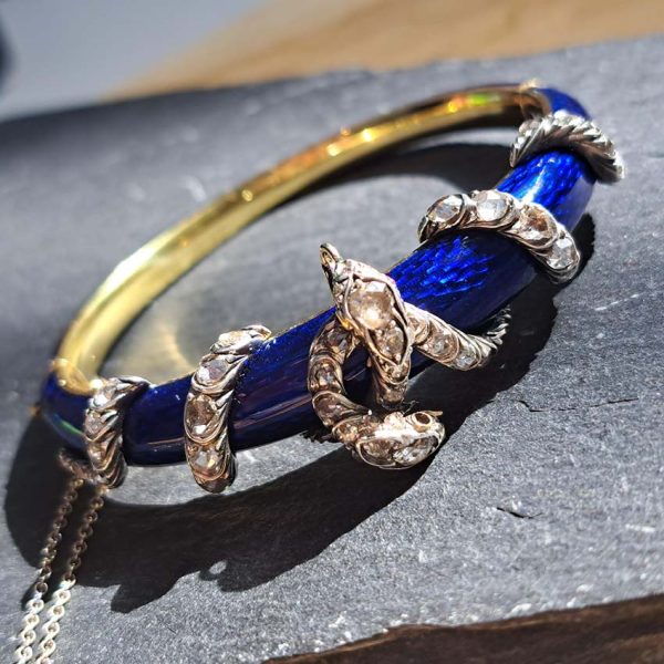 Victorian Antique Blue Enamel and Diamond Set Gold Snake Bangle Bracelet, two entwined diamond set silver snakes on dark blue guilloché enamel tapering hinged gold bangle. Mid 19th century Circa 1850. Presented in antique double door case