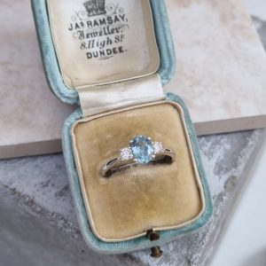 Aquamarine Three stone trilogy engagement ring with a 0.61ct oval cut aquamarine and 0.20ct of round cut diamonds, set in 18ct white gold