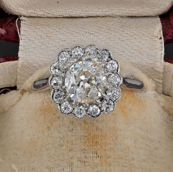 Late Art Deco Diamond Cluster Engagement Ring, 1.60 carats, 1.15ct old European cut diamond within 0.45ct sparkling diamond surround in platinum. Circa 1935