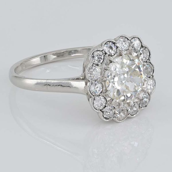 Late Art Deco Diamond Cluster Engagement Ring, 1.60 carats, 1.15ct old European cut diamond within 0.45ct sparkling diamond surround in platinum. Circa 1935