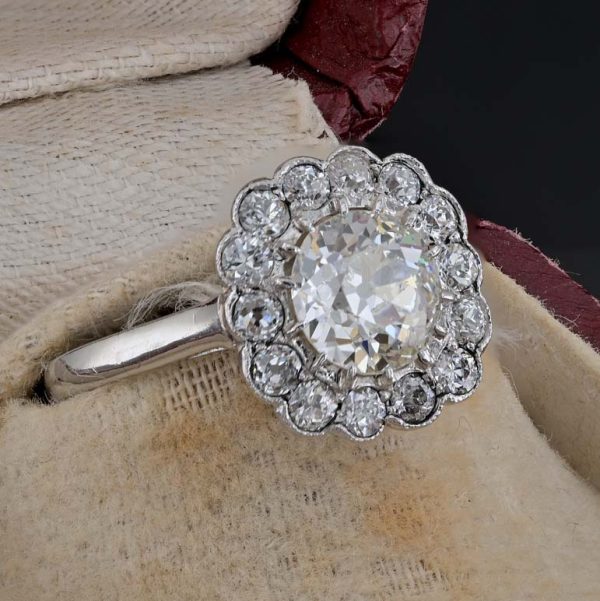 Late Art Deco Diamond Cluster Engagement Ring, 1.60 carats, 1.15ct old European cut diamond within 0.45ct sparkling diamond surround in platinum. Circa 1935