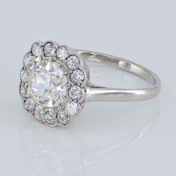 Late Art Deco Diamond Cluster Engagement Ring, 1.60 carats, 1.15ct old European cut diamond within 0.45ct sparkling diamond surround in platinum. Circa 1935