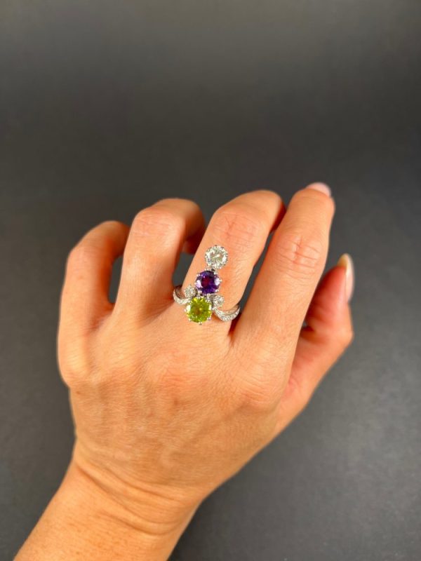 Edwardian Antique French Suffragette Amethyst Peridot Diamond Three Stone Ring, graduating trilogy of peridot amethyst and diamond arranged vertically up the finger when worn in 18ct white gold on diamond-set band with French eagles head stamp