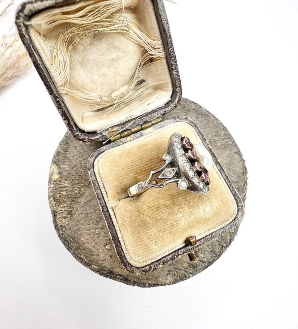 Early Victorian Antique Moonstone Ruby and Diamond Cluster Ring, oval cabochon moonstone surrounded by ruby petals within outer halo border of old-cut diamonds in silver to 18ct yellow gold. Mid 19th century Circa 1865