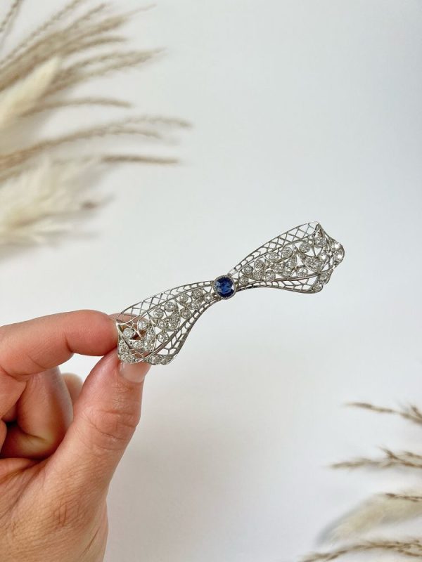 Vintage Antique Art Deco 3.4ct Old Cut Diamond and Sapphire Bow Brooch in Platinum, 1ct old cushion cut sapphire in diamond encrusted platinum decorative pierced framework with original antique velvet-lined fitted box. Circa 1920s