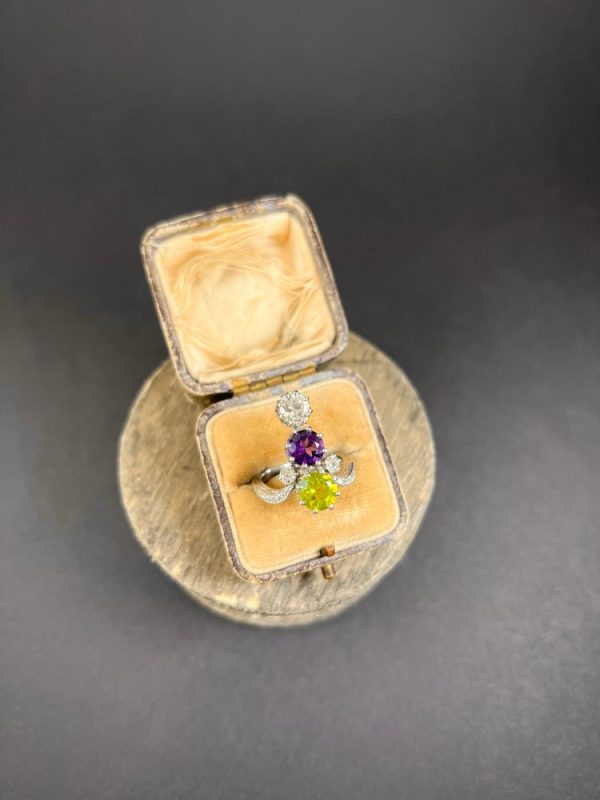 Edwardian Antique French Suffragette Amethyst Peridot Diamond Three Stone Ring, graduating trilogy of peridot amethyst and diamond arranged vertically up the finger when worn in 18ct white gold on diamond-set band with French eagles head stamp