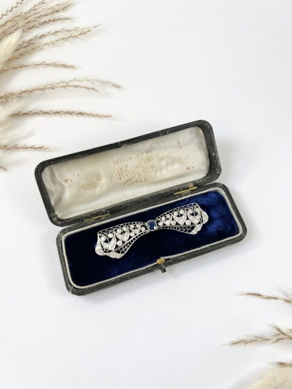 Vintage Antique Art Deco 3.4ct Old Cut Diamond and Sapphire Bow Brooch in Platinum, 1ct old cushion cut sapphire in diamond encrusted platinum decorative pierced framework with original antique velvet-lined fitted box. Circa 1920s