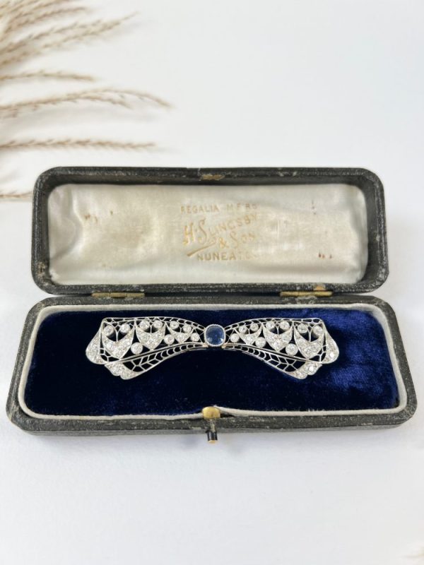 Vintage Antique Art Deco 3.4ct Old Cut Diamond and Sapphire Bow Brooch in Platinum, 1ct old cushion cut sapphire in diamond encrusted platinum decorative pierced framework with original antique velvet-lined fitted box. Circa 1920s