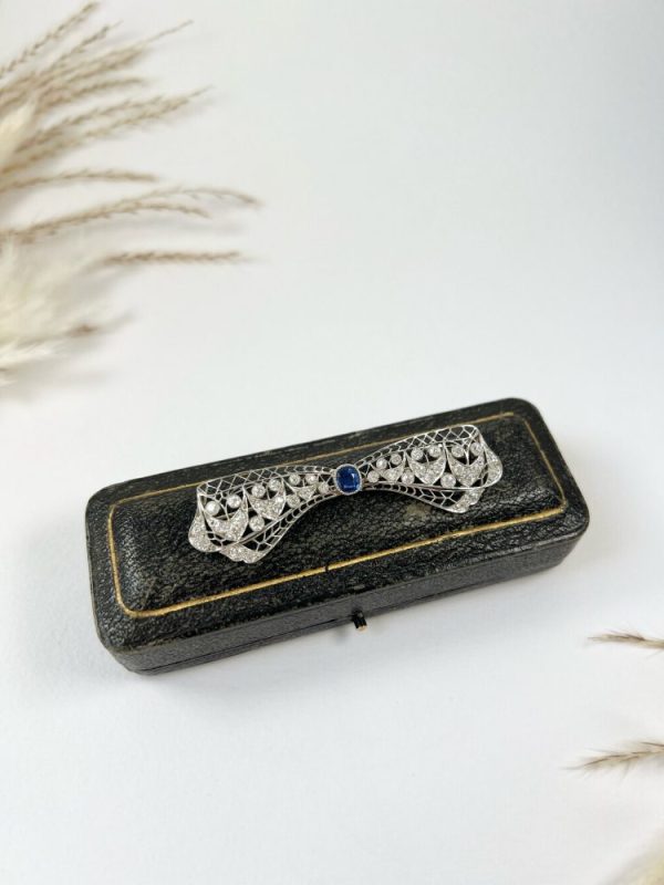 Vintage Antique Art Deco 3.4ct Old Cut Diamond and Sapphire Bow Brooch in Platinum, 1ct old cushion cut sapphire in diamond encrusted platinum decorative pierced framework with original antique velvet-lined fitted box. Circa 1920s