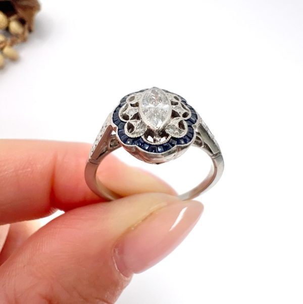 Art Deco Inspired Marquise Diamond and Sapphire Cluster Dress Ring in Platinum, marquise-cut diamond within diamond set intricate open-work design surround and outer border of calibre sapphires. Circa 2000